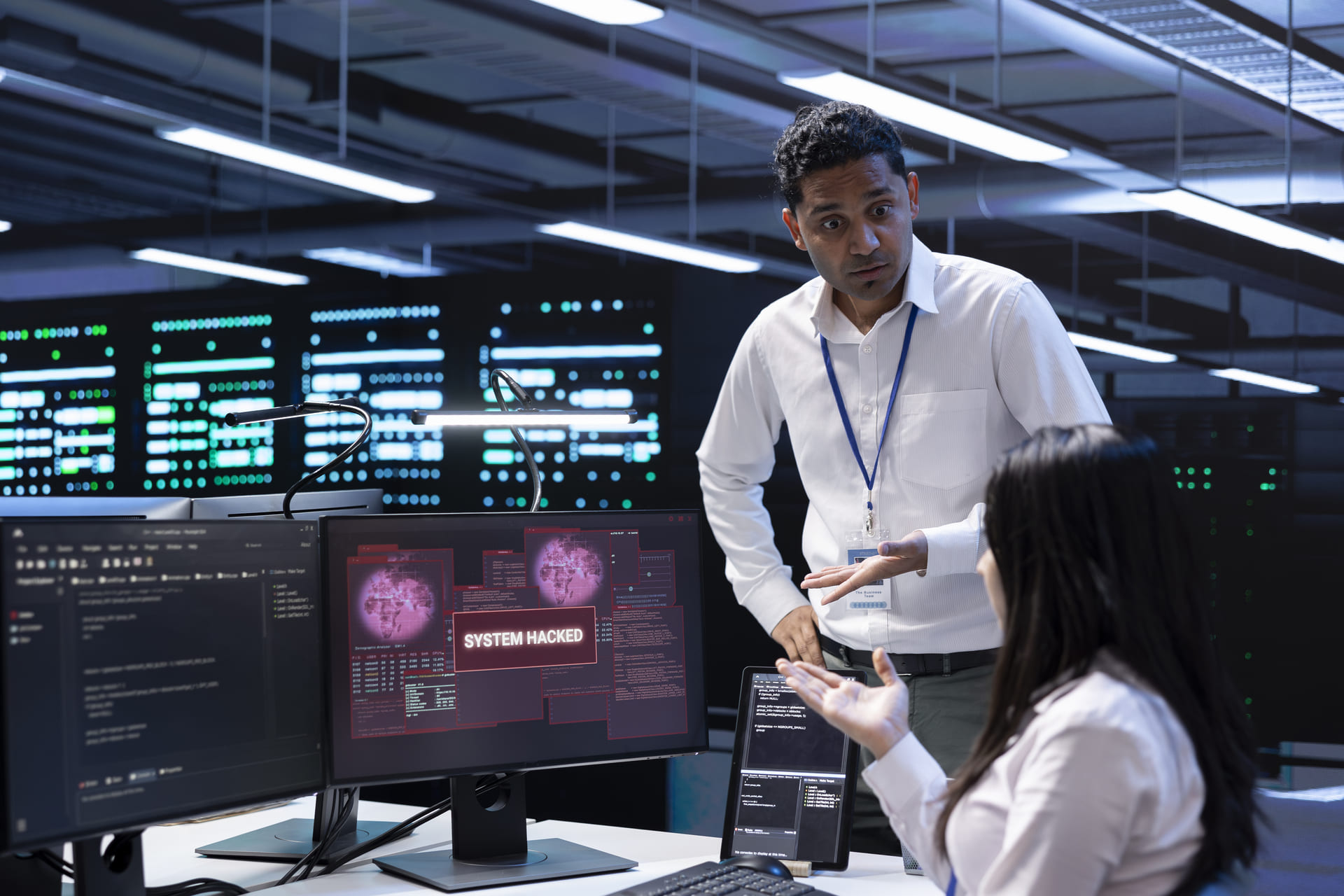 IT team discussing a system hack alert on a computer screen | CMIT Solutions IT team discussing a system hack alert on a computer screen