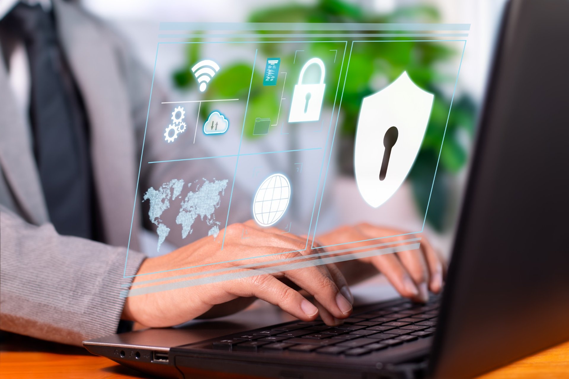 Person typing on a laptop with digital cybersecurity icons overlaid