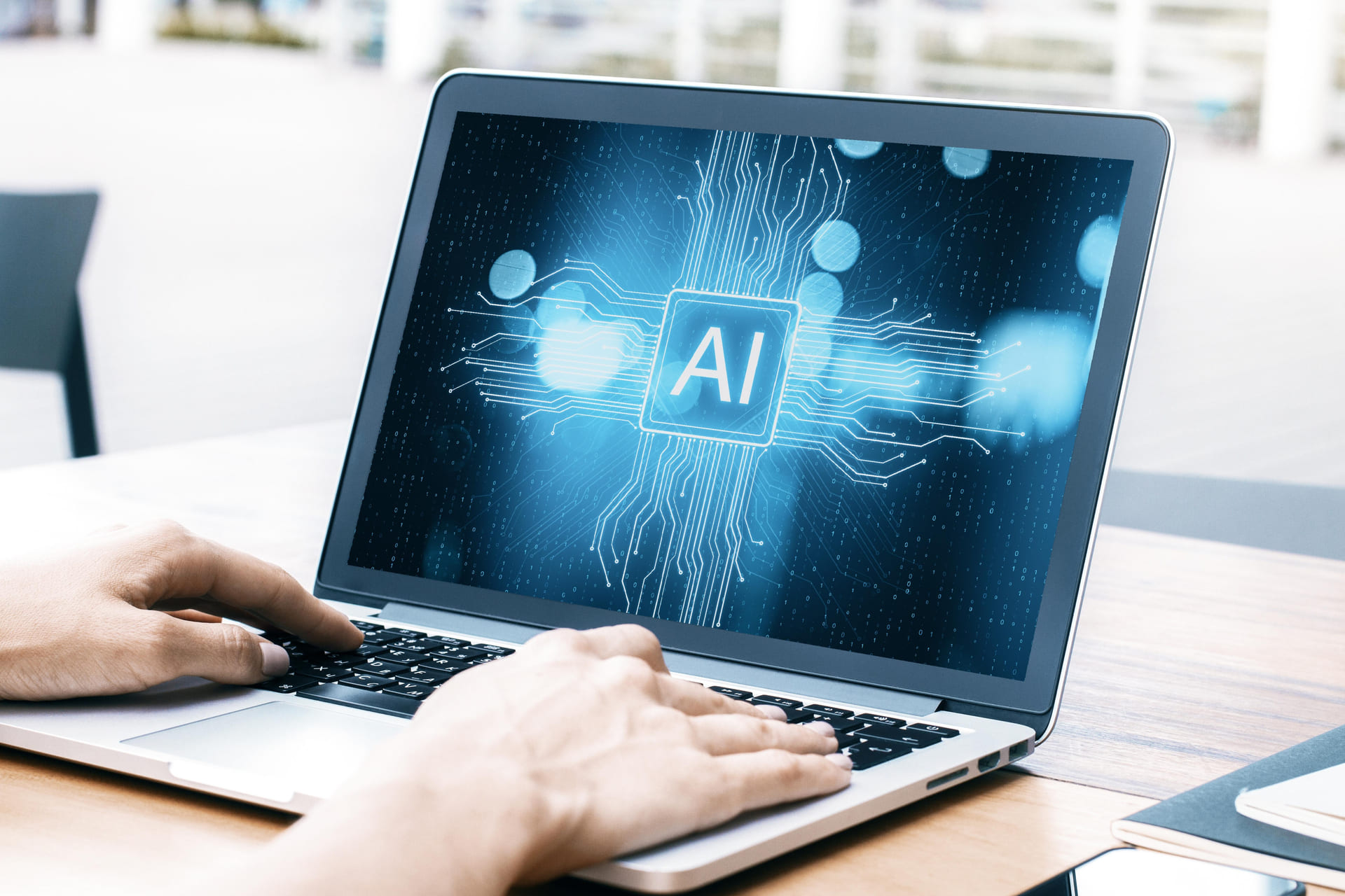Person using laptop displaying AI graphic