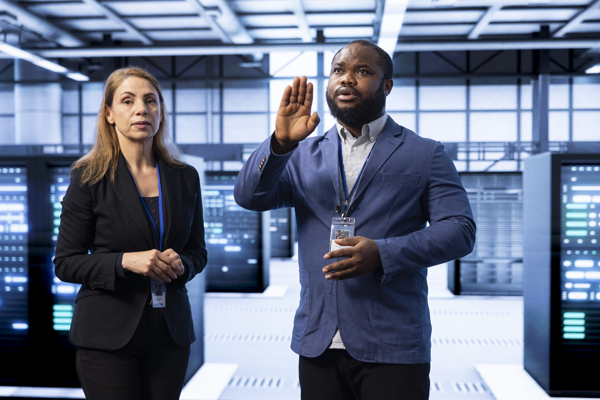 Two IT professionals discussing in a data center with server racks