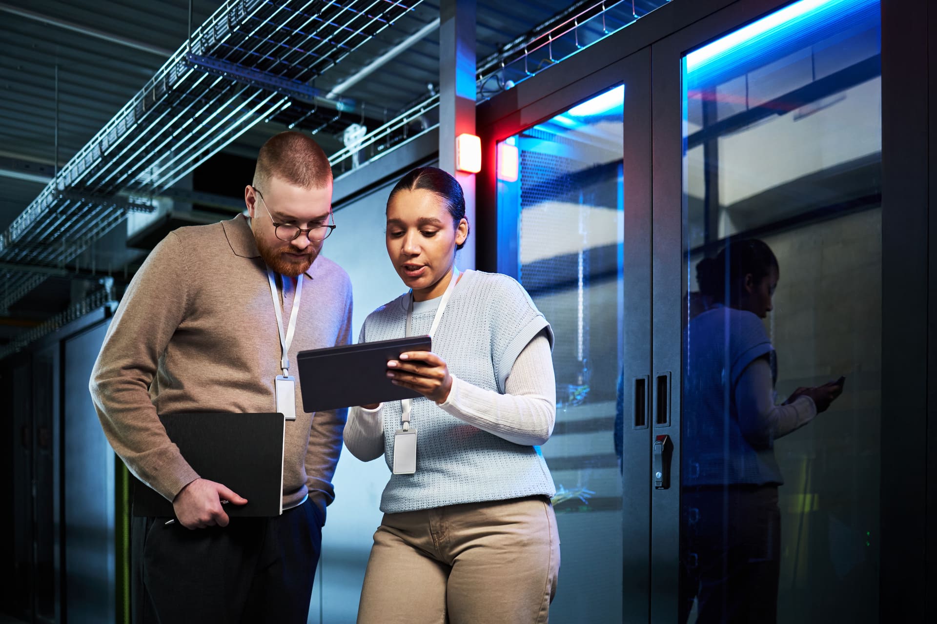 Two IT specialists discussing data security strategies in a server room