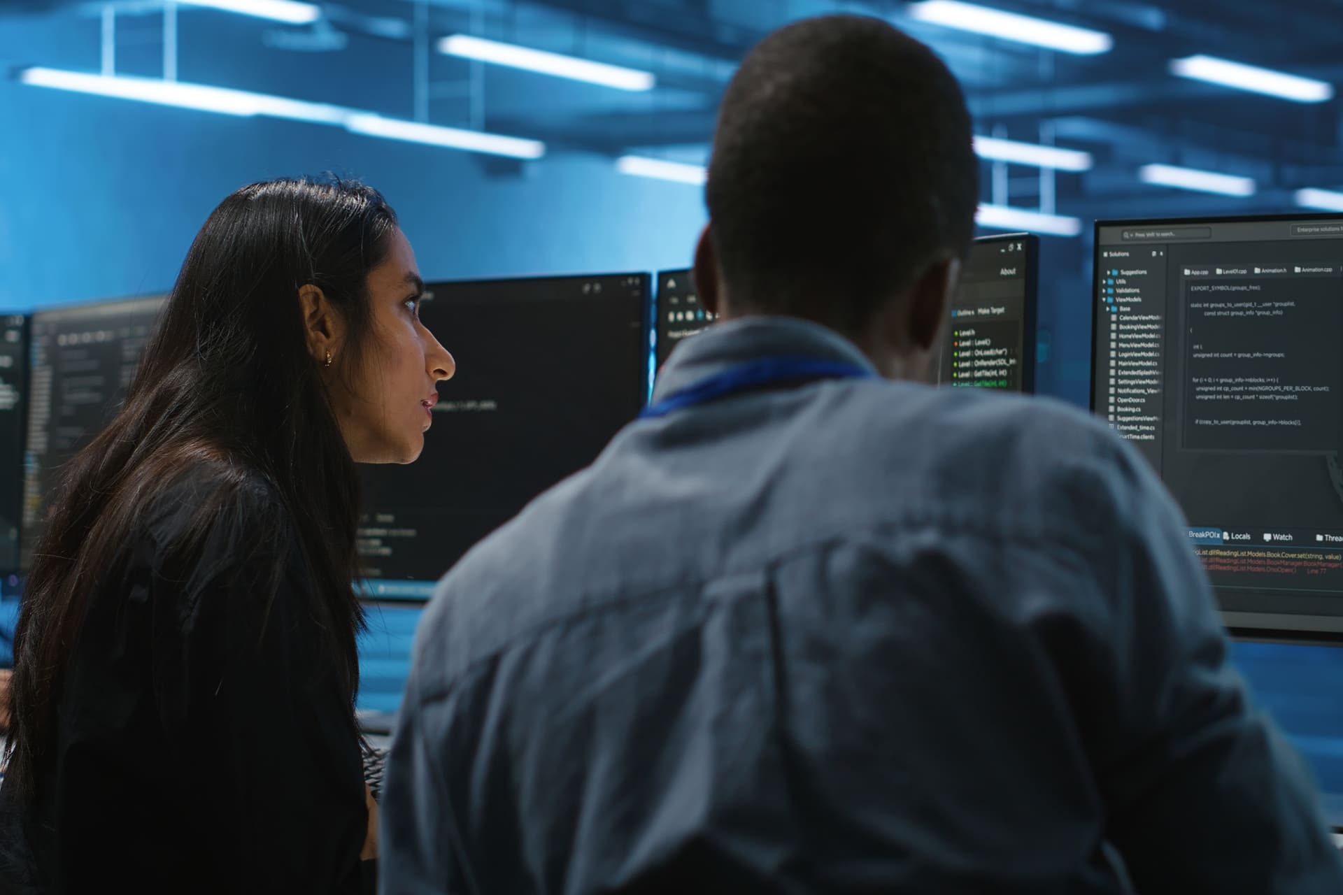 Two developers reviewing code on computer monitors