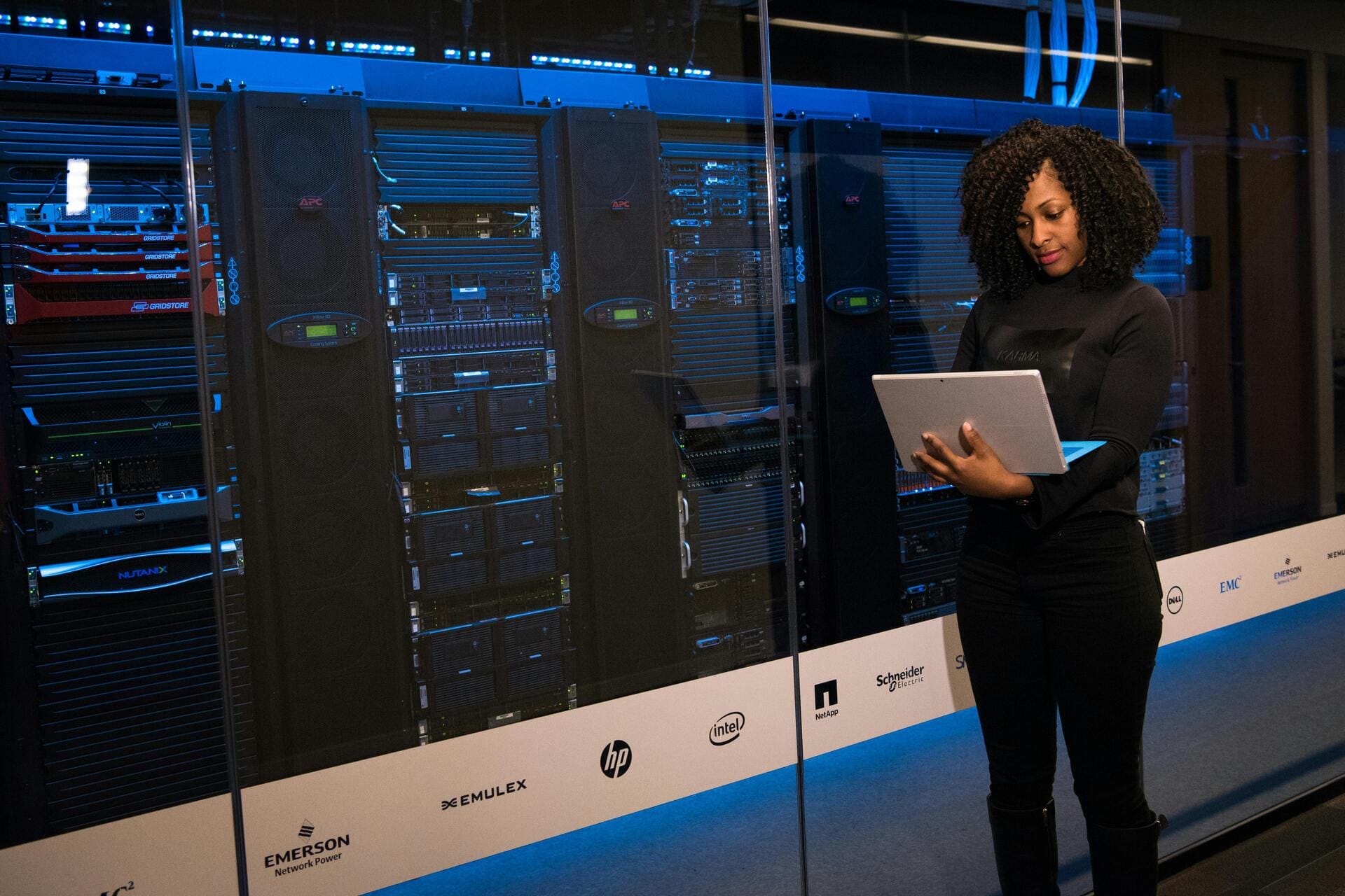 Woman using laptop in a server room