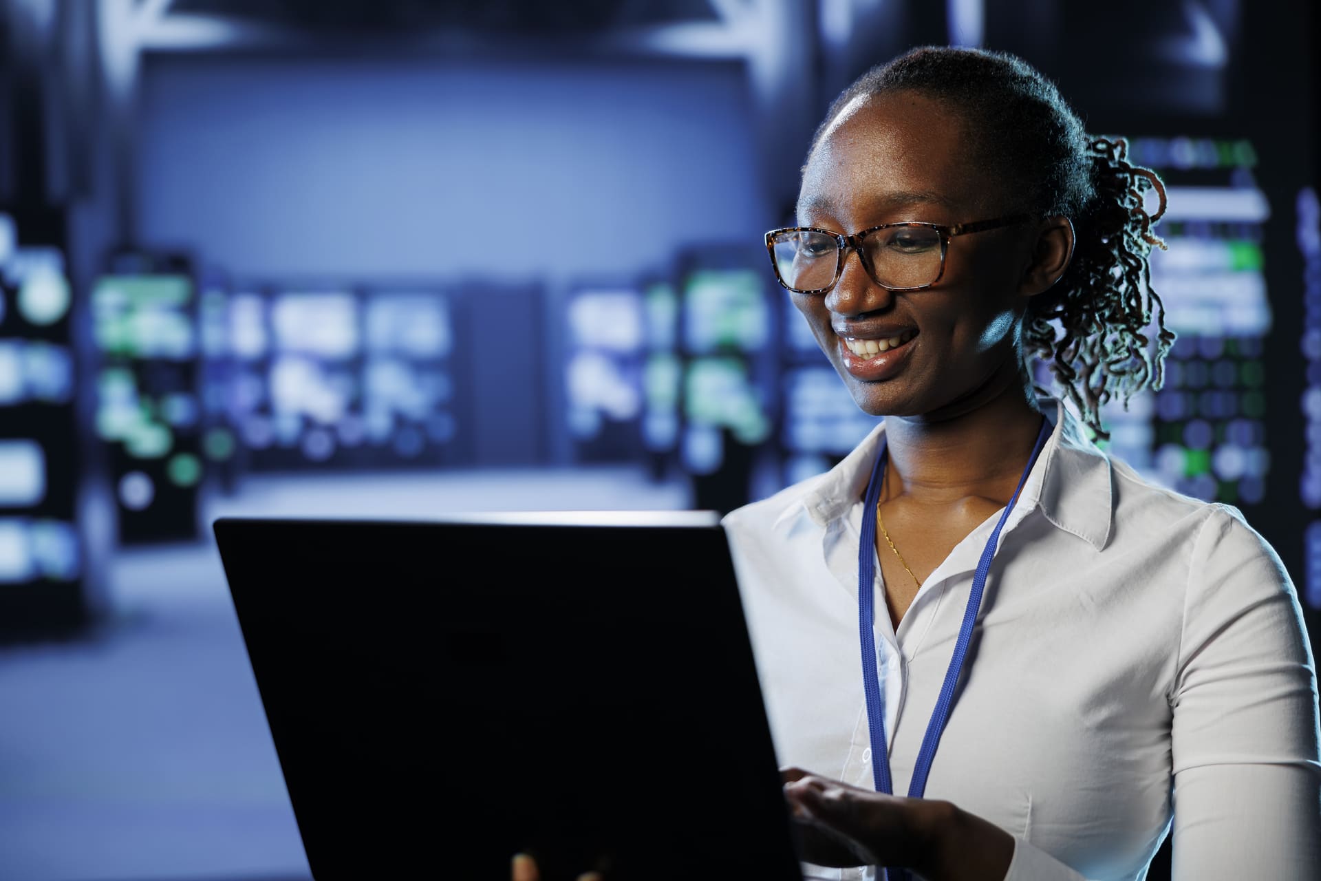 Female cybersecurity analyst using a laptop in a data center
