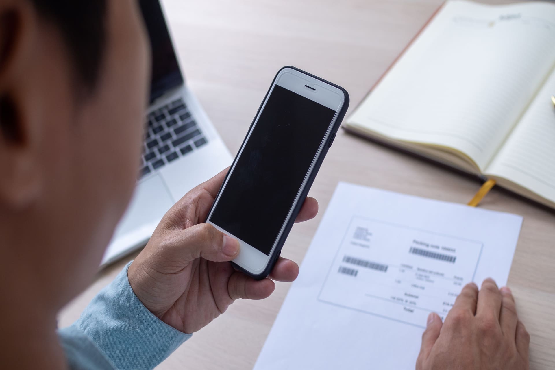 Person scanning a QR code on paper using a smartphone