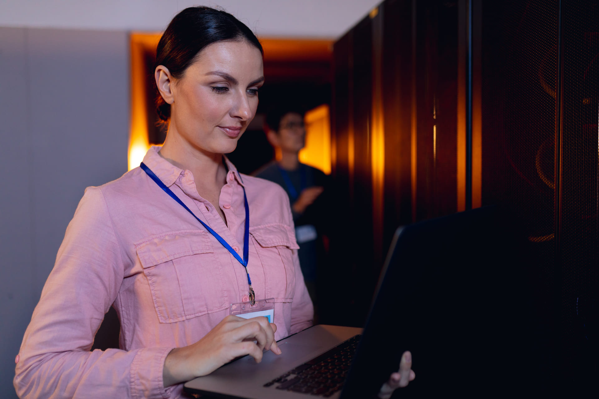 IT engineer using laptop in a secure server room