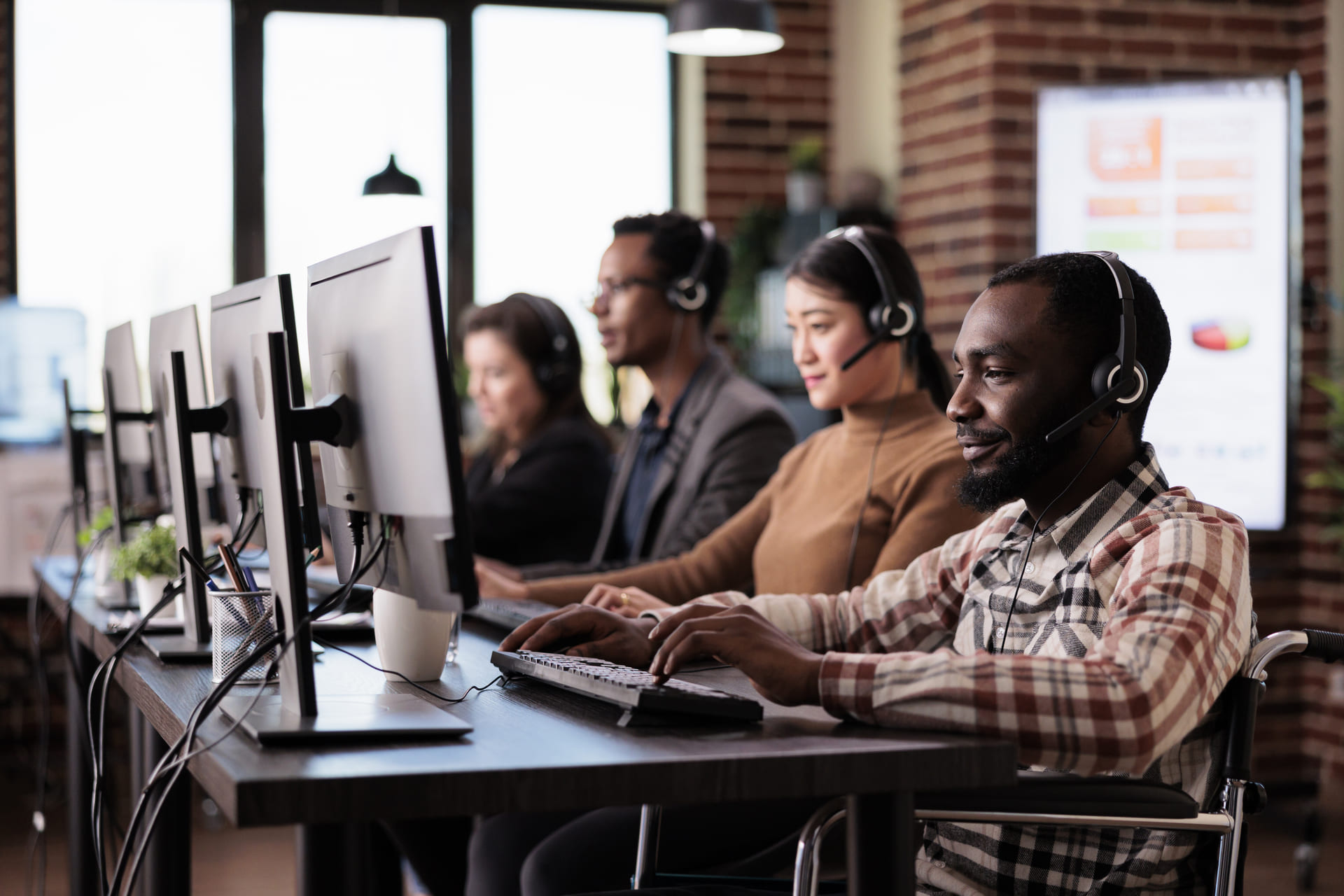 Customer support team working at computers with headsets