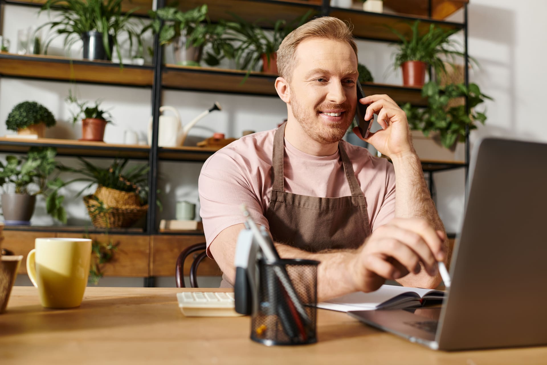 Small business owner on phone while working on laptop