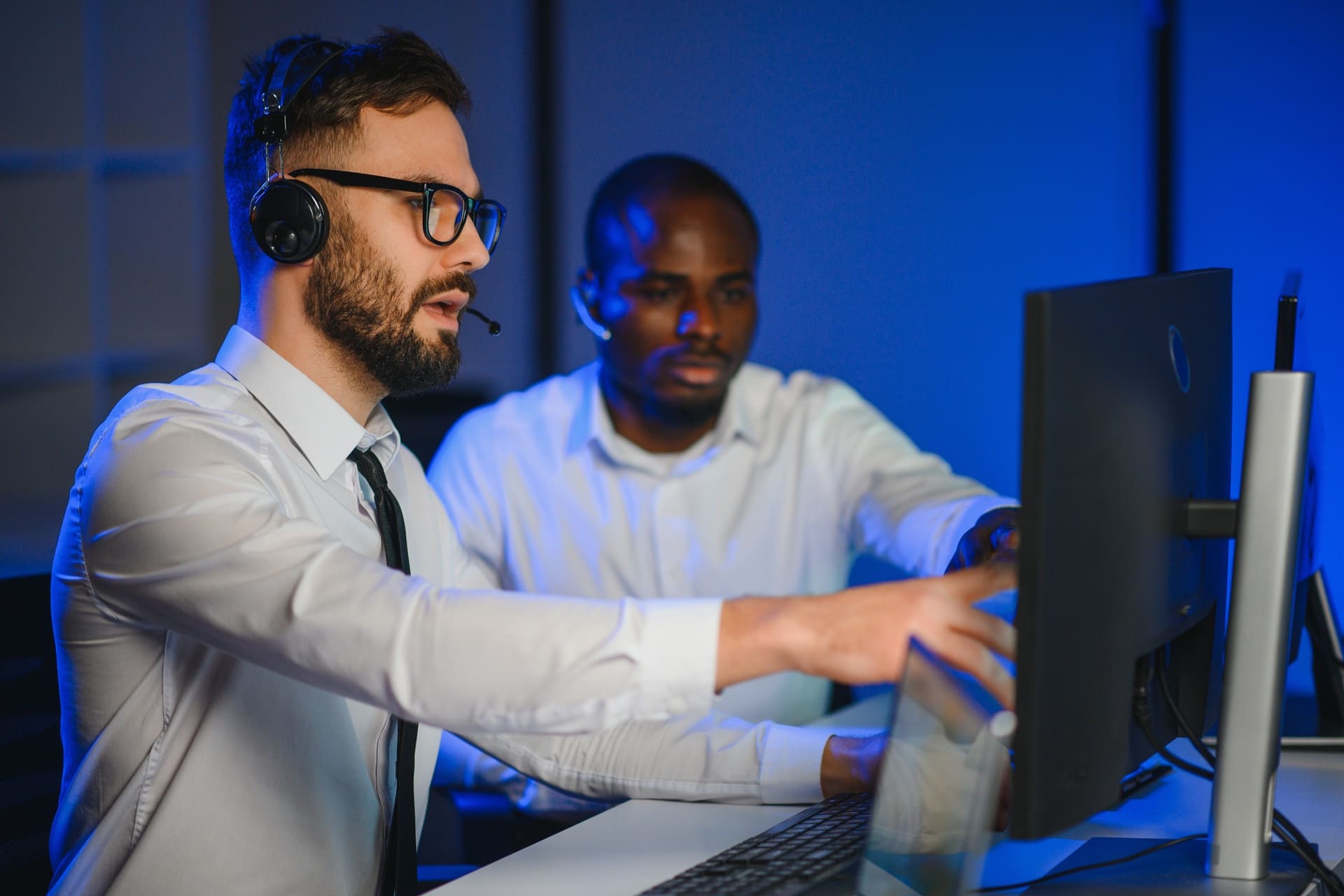 Technical support specialists collaborating at computer workstation
