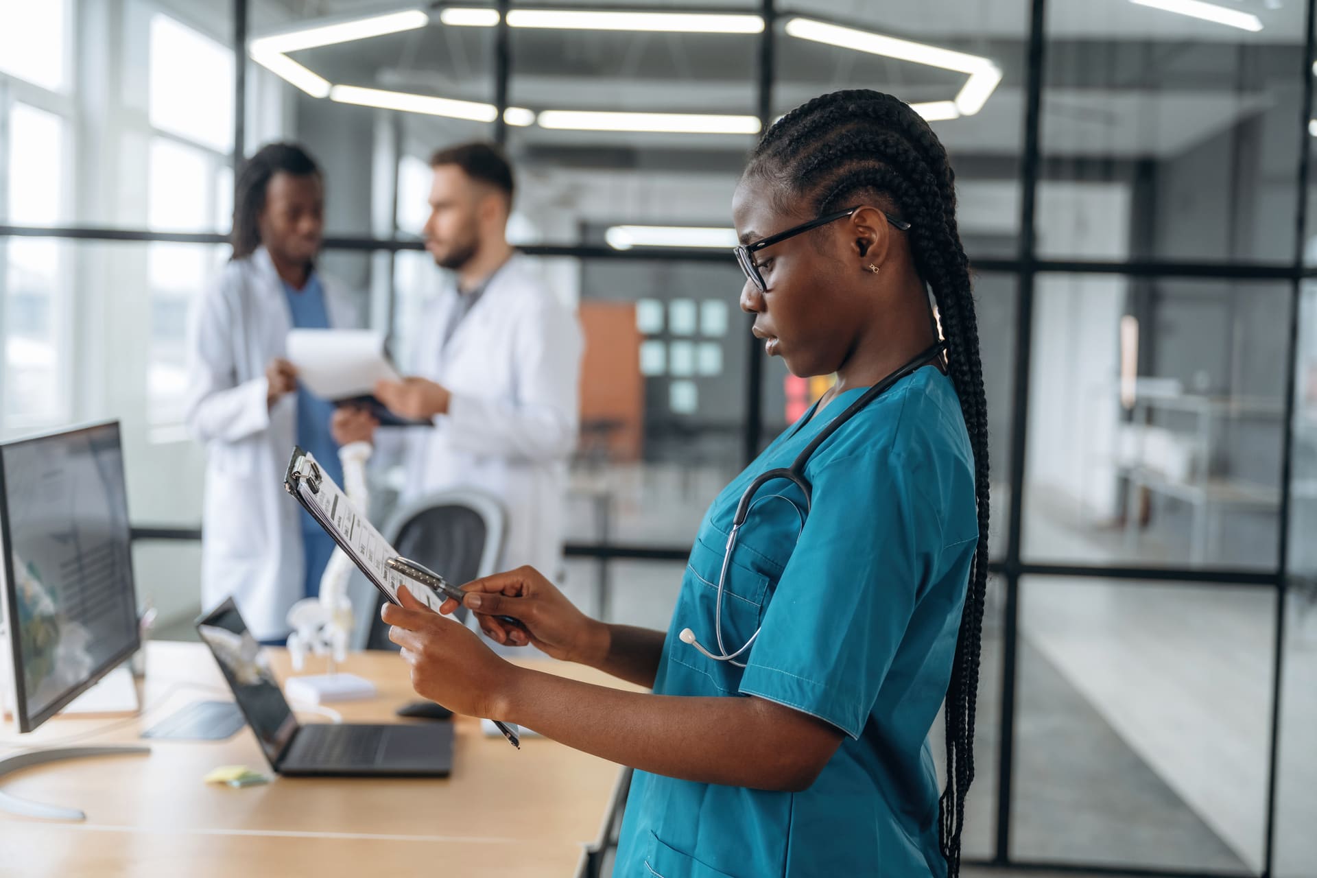 Nurse reviewing clipboard in modern office | CMIT Solutions Nurse reviewing clipboard in modern office