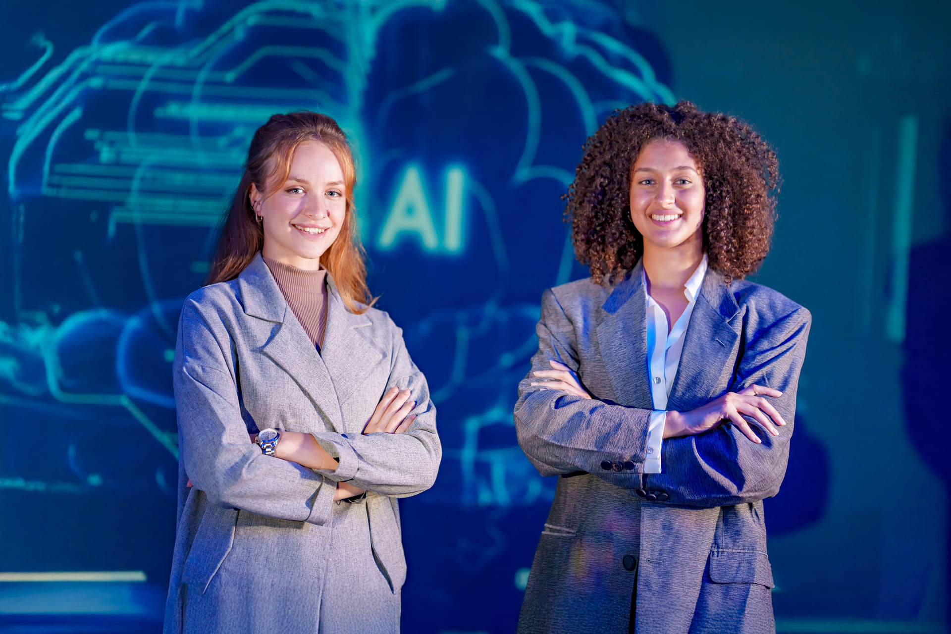 two-women-stand-together-in-suits-at-a-technology-office | CMIT Solutions two-women-stand-together-in-suits-at-a-technology-office