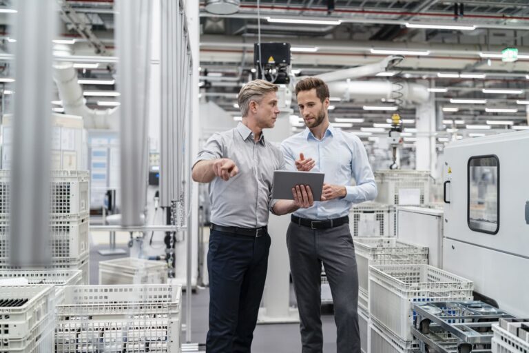 two-businessmen-with-tablet-talking-in-a-modern-factory