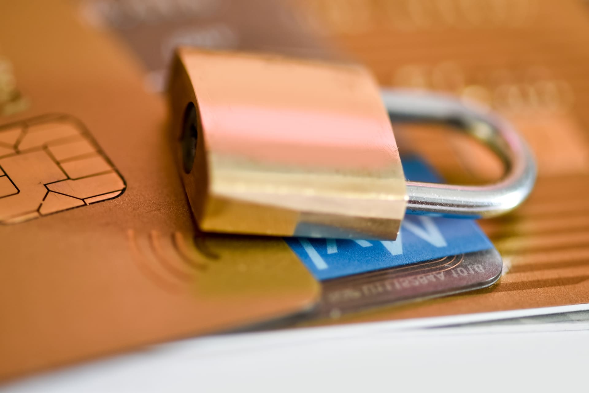 padlock-secures-credit-cards-financial-security-concept | CMIT Solutions Close-up of a brass padlock resting on stacked credit cards, symbolizing security for payment info.