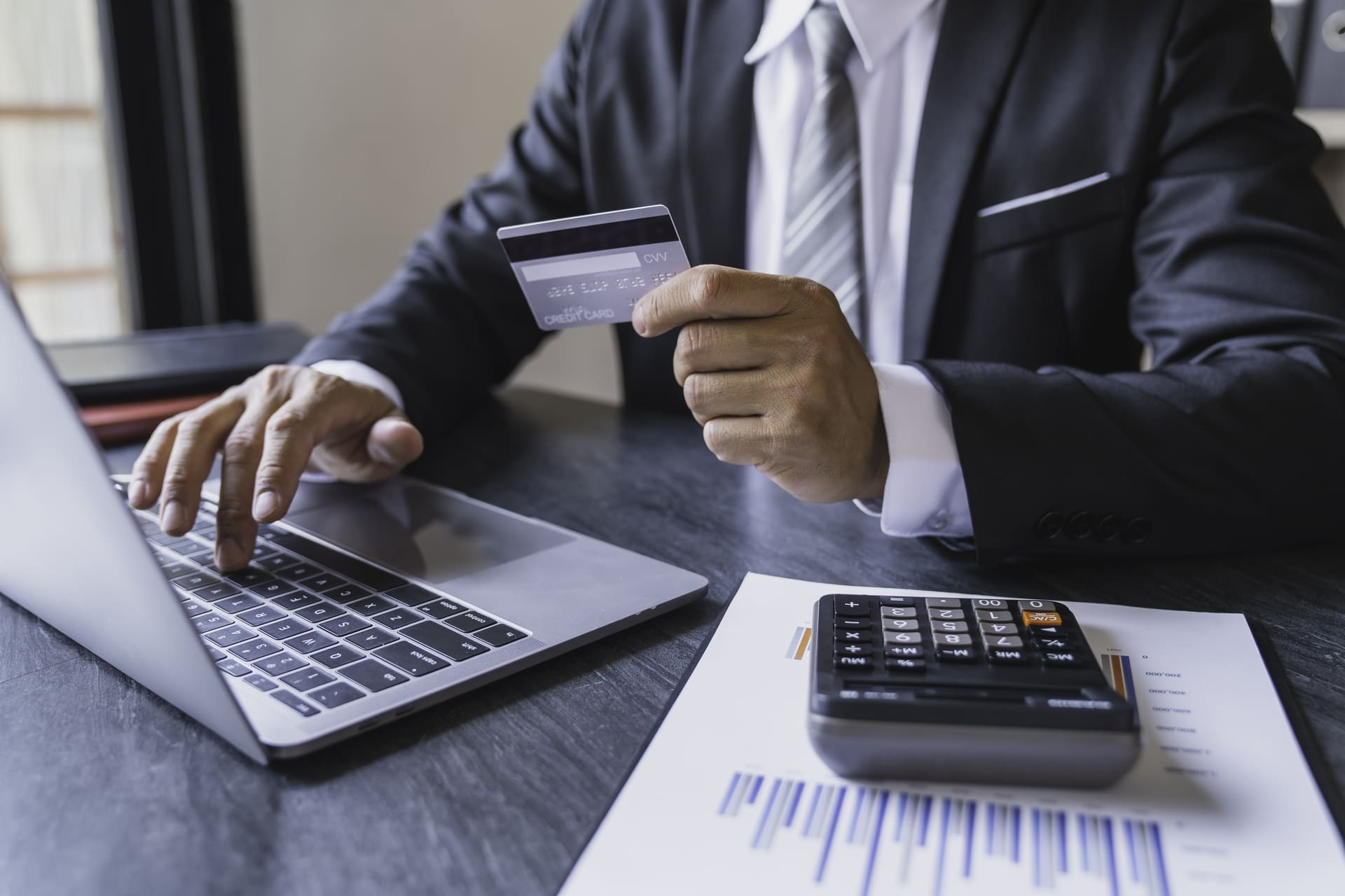 professional-at-desk-using-credit-card-and-laptop | CMIT Solutions professional-at-desk-using-credit-card-and-laptop