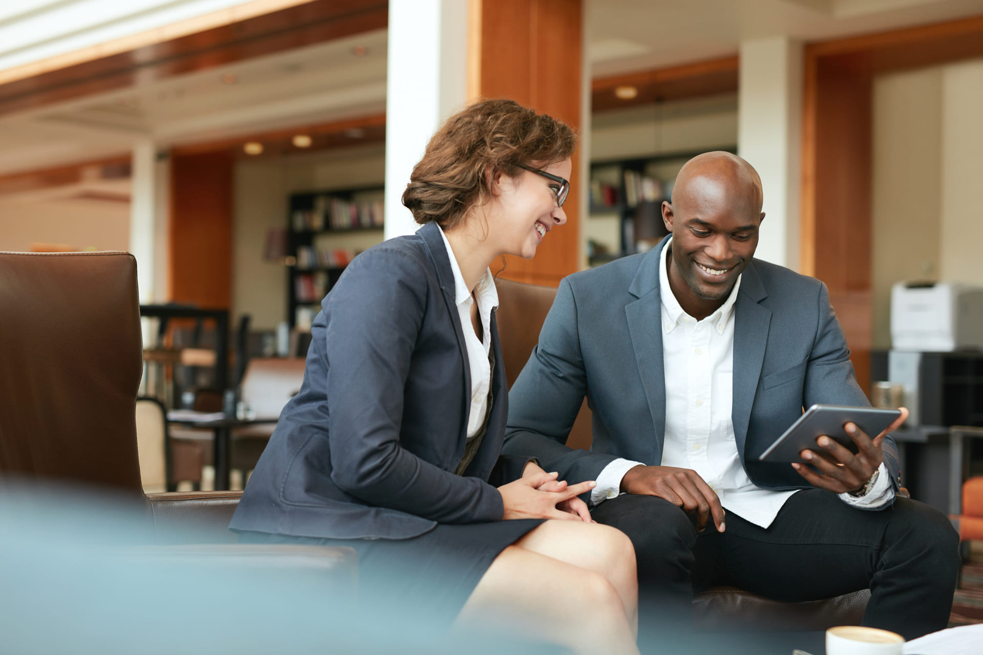 smiling-business-people-using-digital-tablet-at-office | CMIT Solutions smiling-business-people-using-digital-tablet-at-office