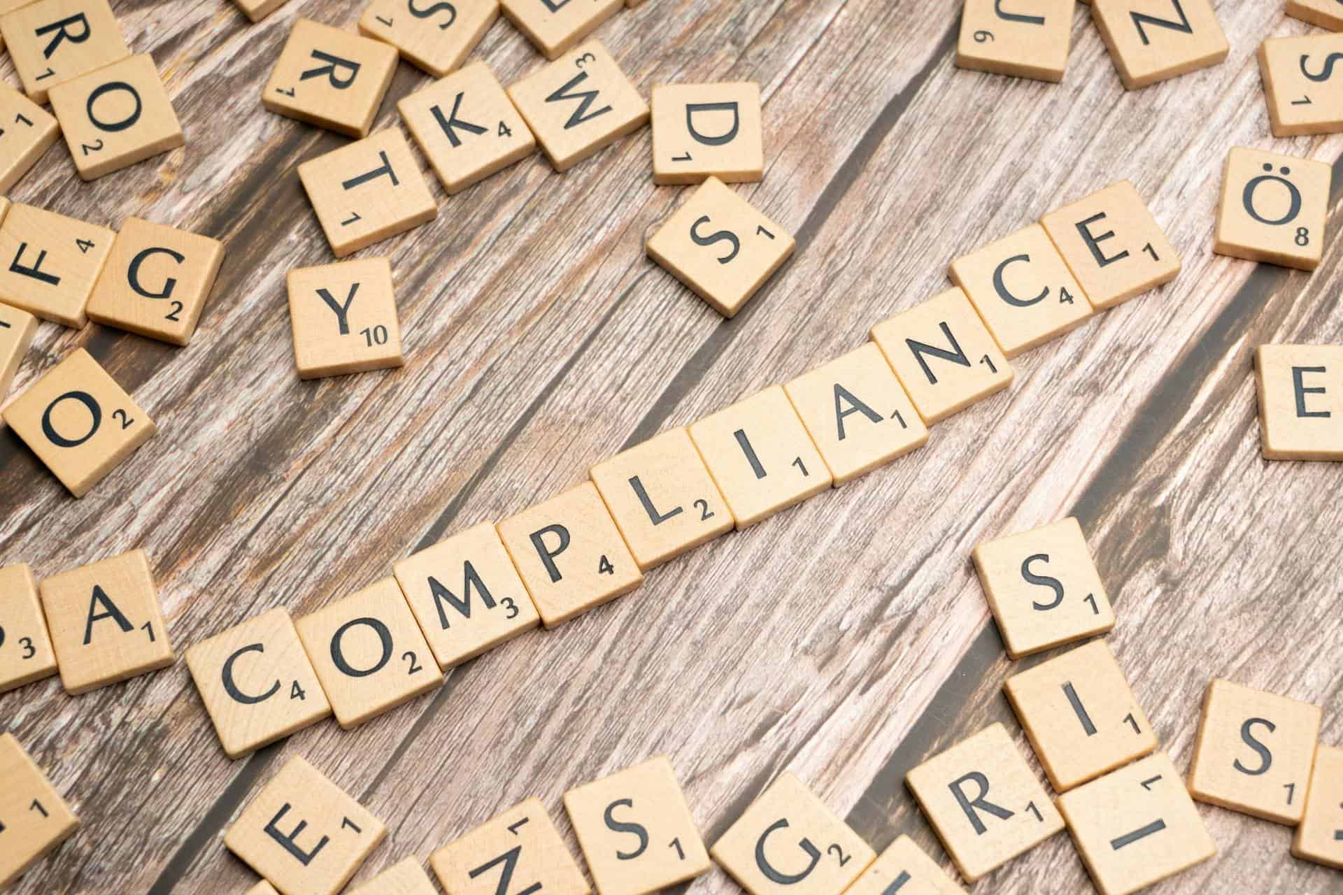 compliance | CMIT Solutions Scrabble tiles on a wooden table spell out the word 'COMPANIES'.