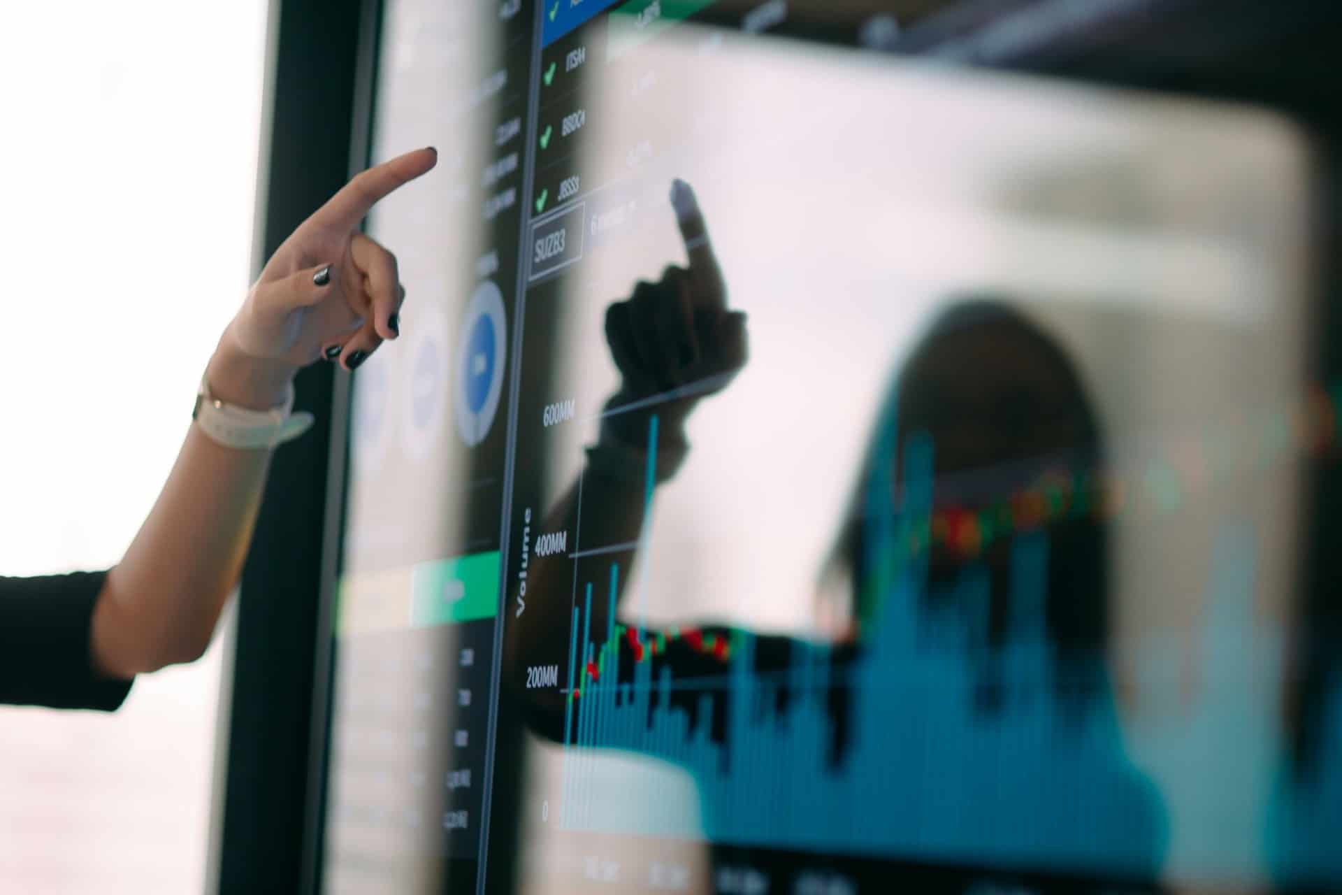 financial-data-analytics-dashboard | CMIT Solutions Person interacting with a digital dashboard displaying financial charts and market data.