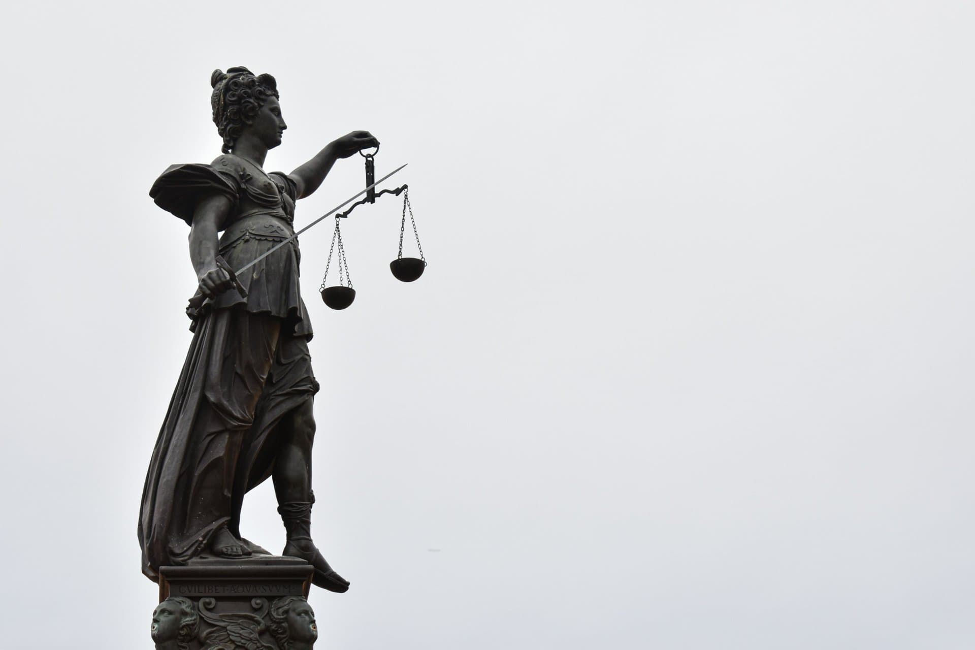 justice-scales-statue | CMIT Solutions Outdoor statue of Lady Justice holding scales and a sword.