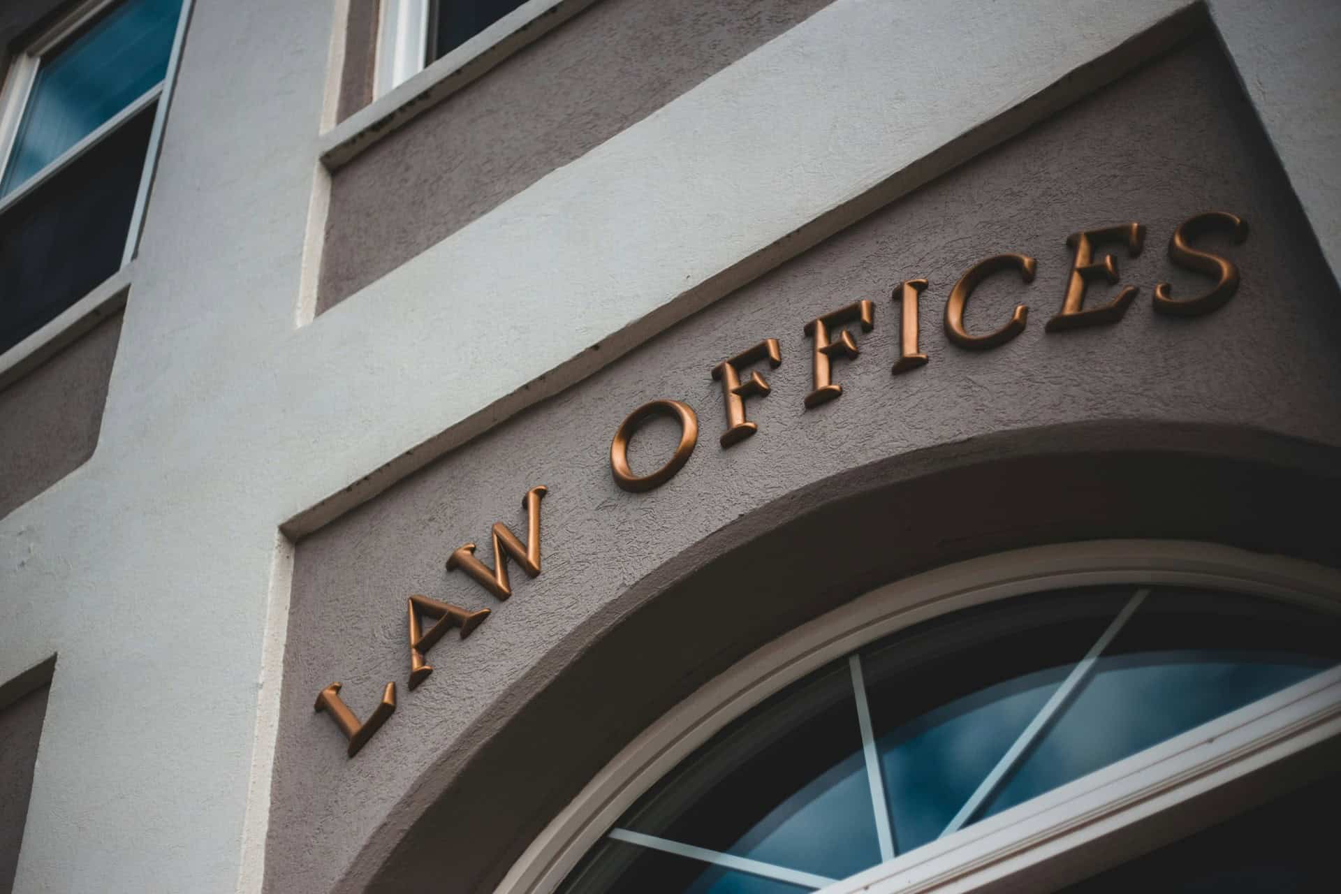 law-office-building-exterior | CMIT Solutions Close-up of bronze LAW OFFICES lettering above an arched window on a professional building facade.