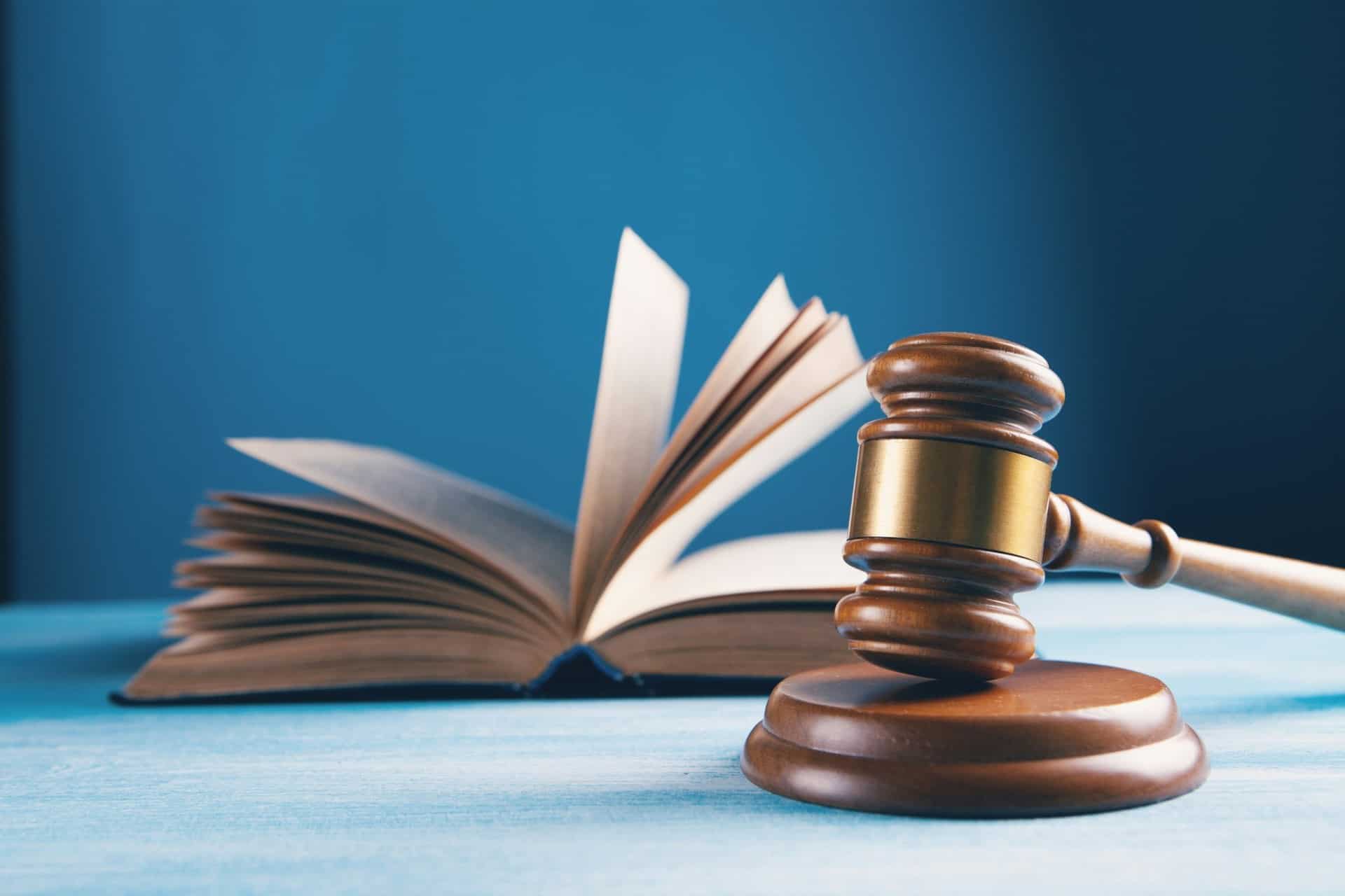 legal-regulations | CMIT Solutions Gavel on a desk with an open book in the background, symbolizing law and justice.