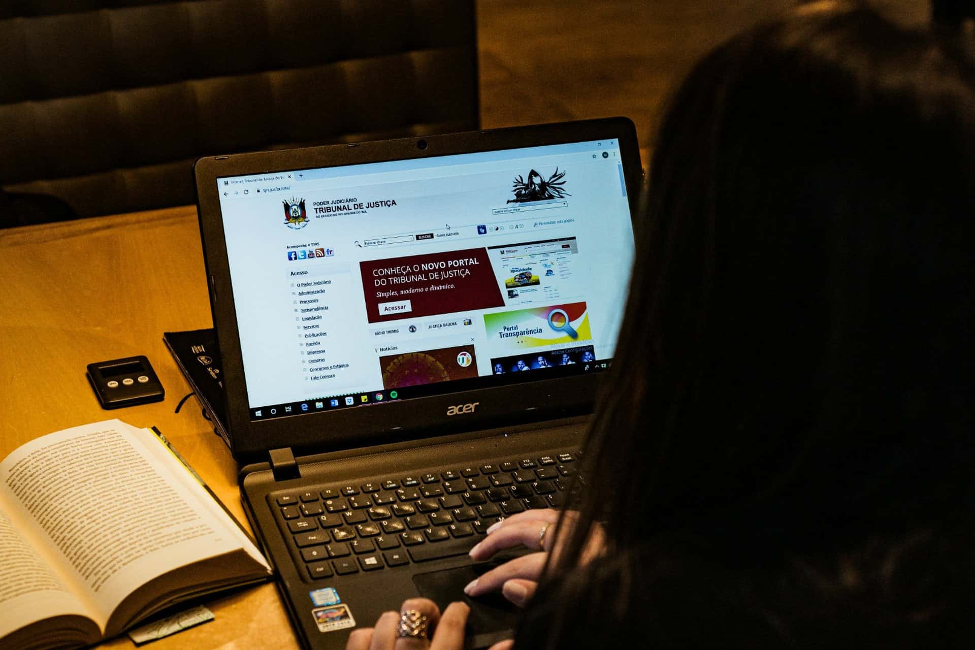 mateus-campos-felipe-n4CLHNL5n6Y-unsplash-1920x1280 | CMIT Solutions Person researching legal information on a laptop beside an open book.