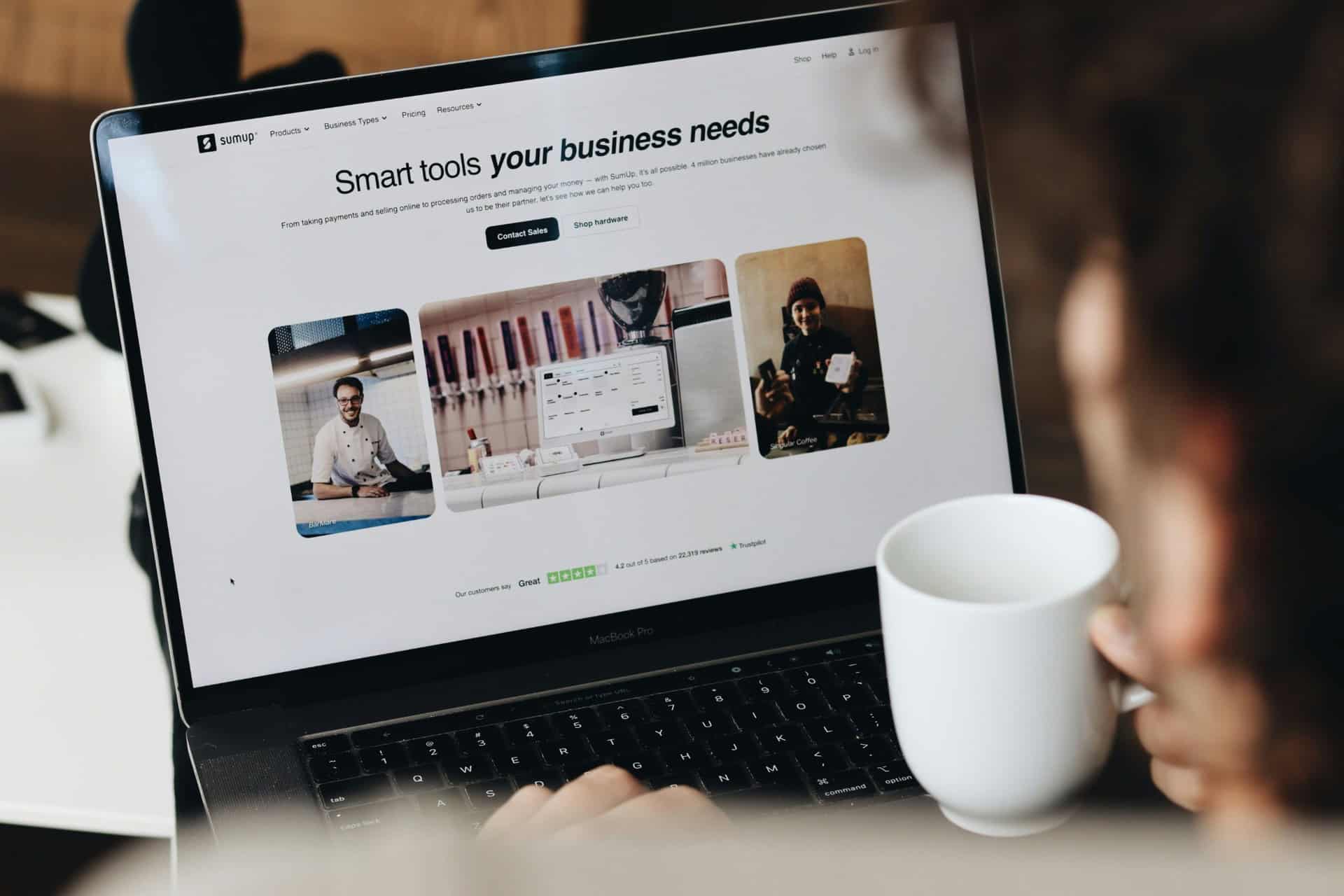 small-business-payment-tools-website | CMIT Solutions Laptop displaying a business payment services website beside a coffee mug.