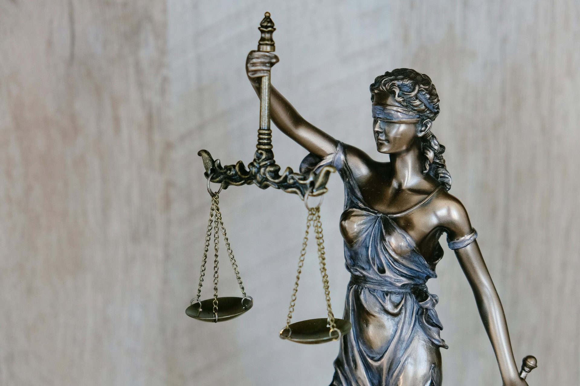 tingey-injury-law-firm-DZpc4UY8ZtY-unsplash 1 | CMIT Solutions Bronze statue of Lady Justice, blindfolded, holding the scales of justice