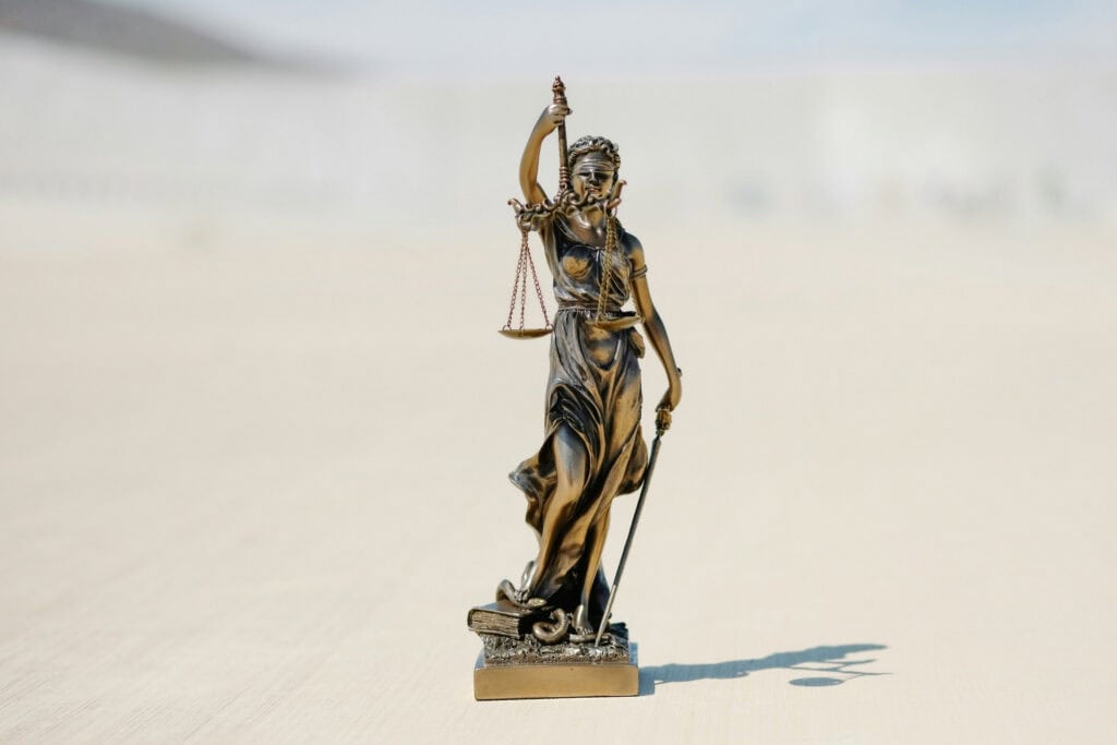 Bronze Lady Justice statue holding scales and sword symbolizing law and fairness.